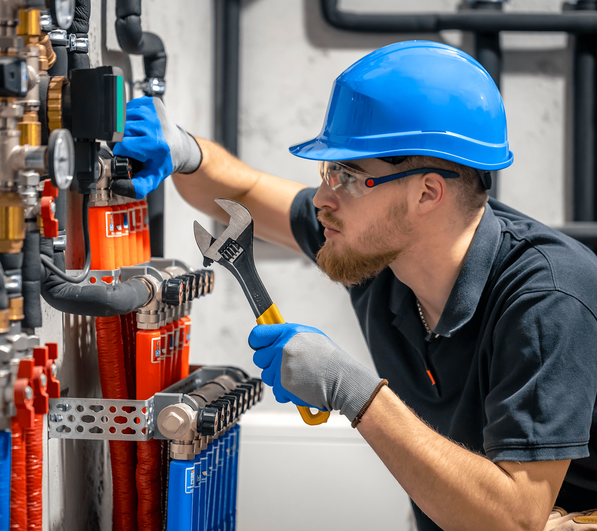Worker adjusting pipes with a wrench.
