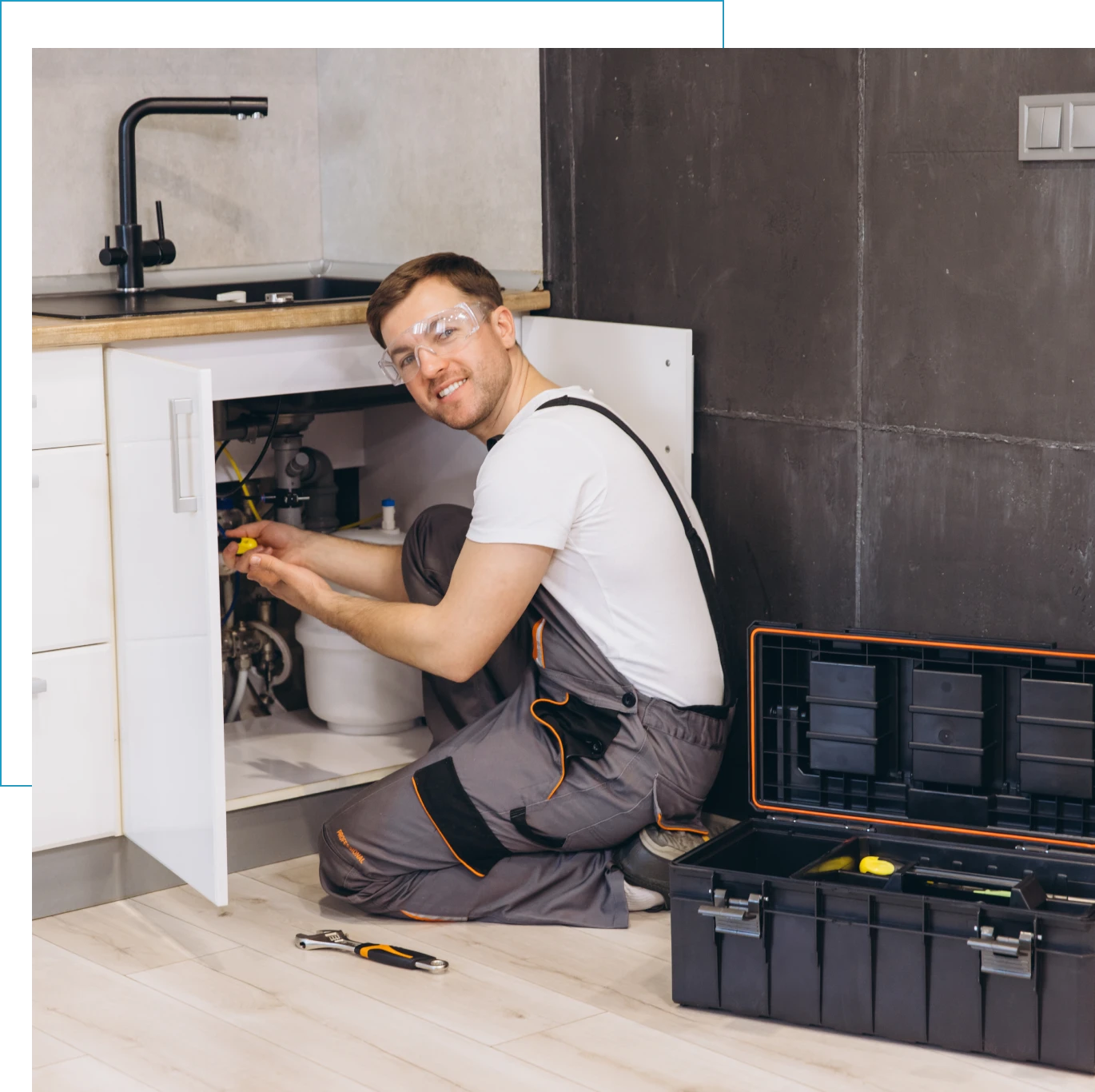 Plumber fixing sink with tools nearby.